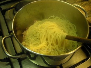 scola la pasta e versala sul soffritto di pancetta e aglio