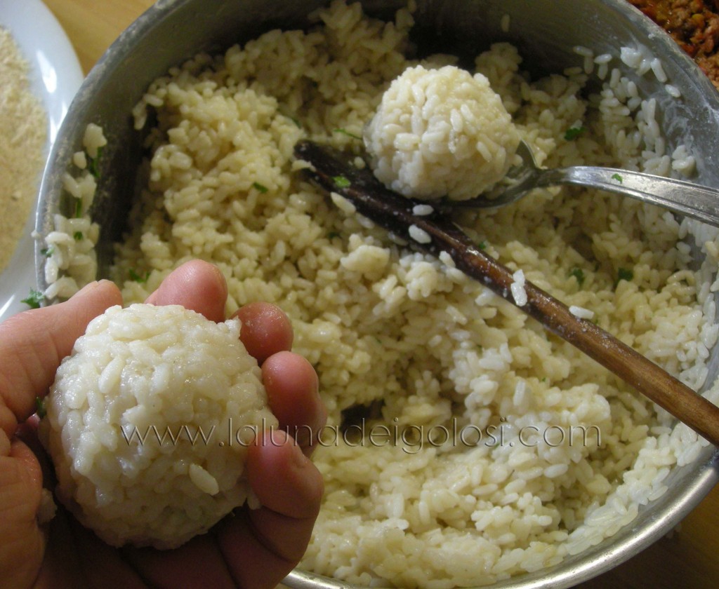 prendi il riso a cucchiaiate e aiutandoti con le mani fai tante palle di riso