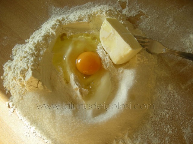 Crostata alla marmellata: setaccia la farina, metti lo zucchero, il burro e le uova