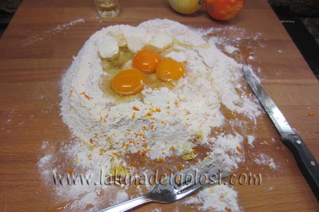 setaccia la farina e aggiungi tutti gli ingredienti: le uova, lo zucchero, il liquore, un pizzico di sale, le scorze grattiugiate