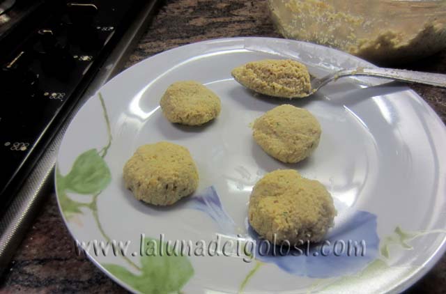 prepara le polpette: prendi l'impasto a cucchiaiate e schiaccialo bene tra le mani