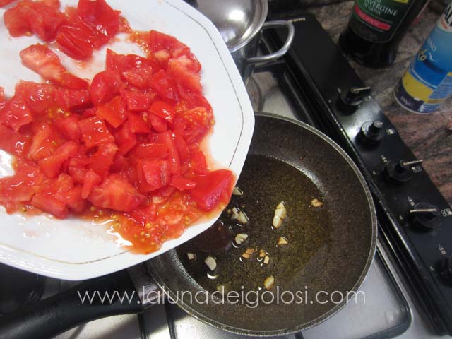 soffriggi l'aglio e metticii i pomodori tagliati a pezzi