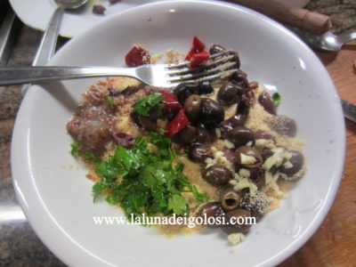 in un piatto metti il pangrattato, le olive, le  acciughe,  il prezzemolo, l'aglio, il peperoncino, i capperi, tutto ridotto a pezzetti