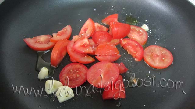 Quando è caldo, metti gli spicchi d’aglio e poi aggiungi i pomodori